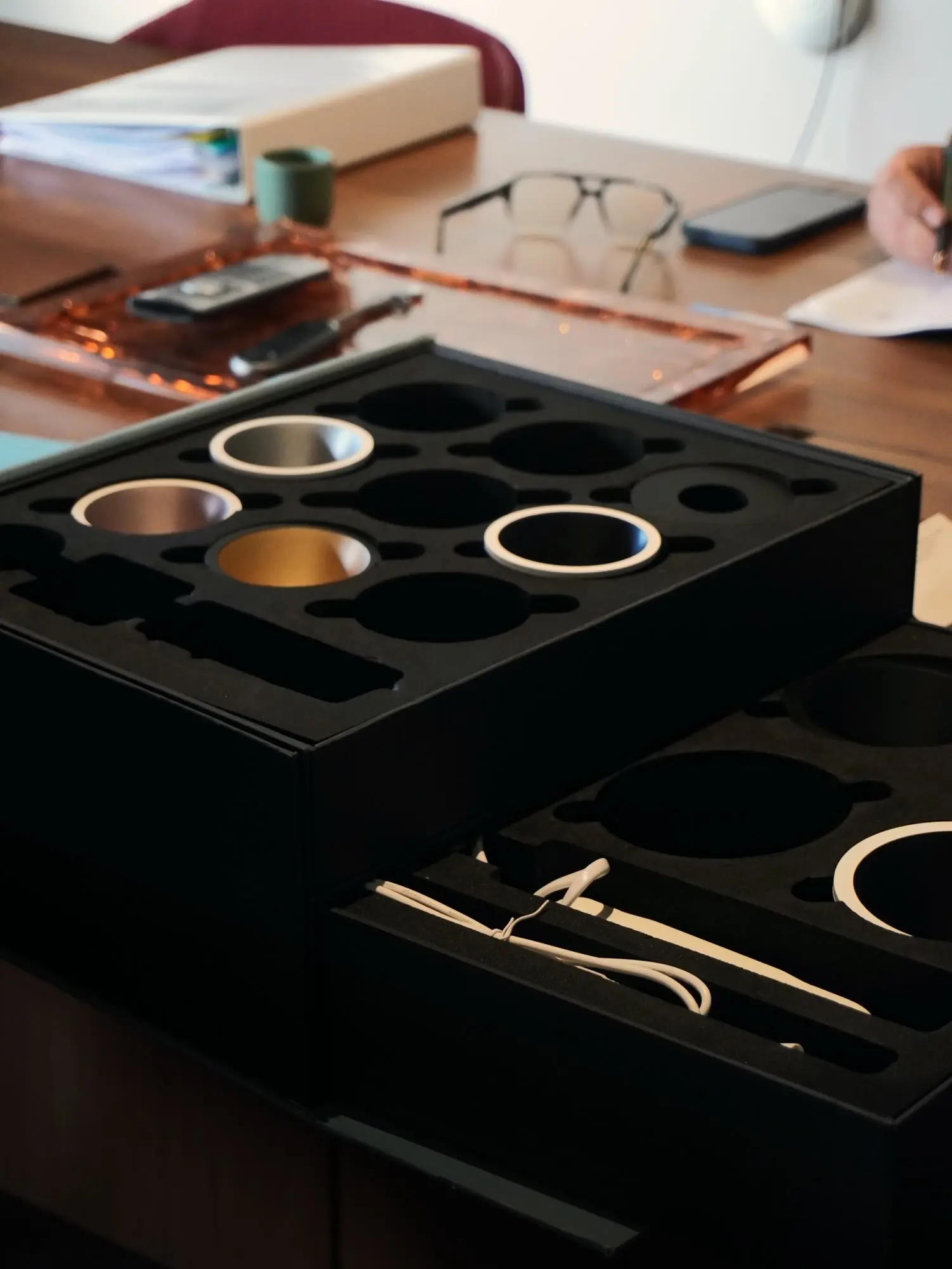 Coffret d'échantillons de spots, finitions or et argent, sur la table de réunion